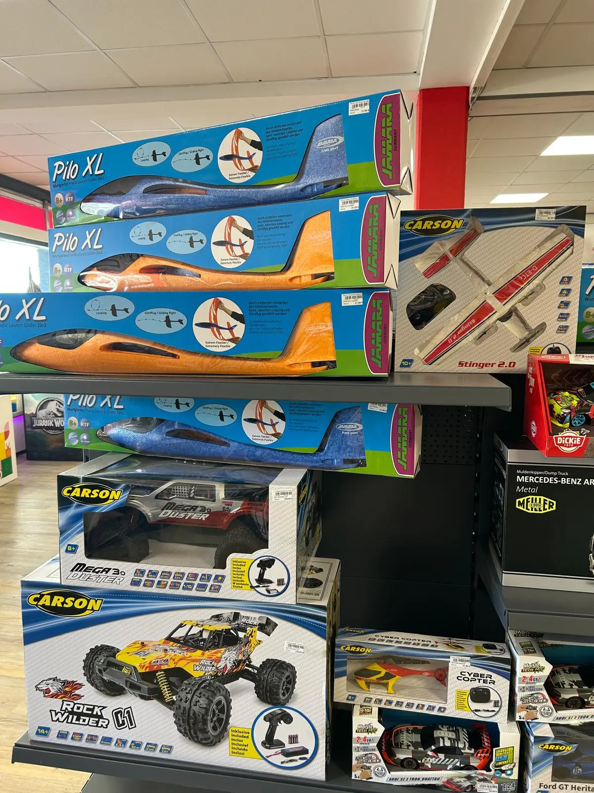 Regal mit Carson-RC-Autos und Pilot-XL-Wurfgleitern